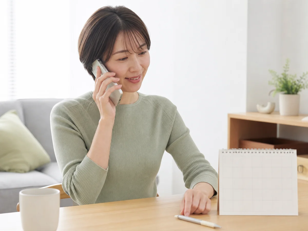 受付へ予約変更を連絡する患者